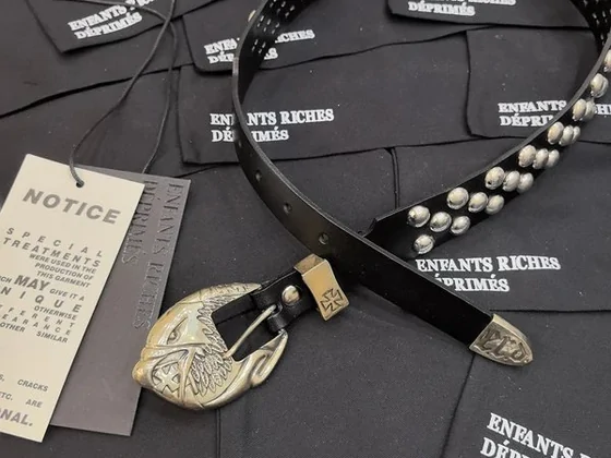 A black belt with domed studs and an engraved metal buckle
