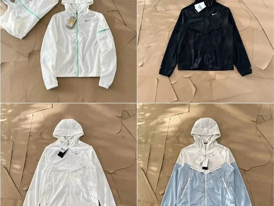 Four lightweight hooded windbreakers in white, black and pale blue
